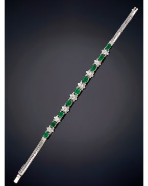 243-ELEGANTE PULSERA DE BRILLANTES Y ESMERALDAS, diseño a modo de rosetón de brillantes flanqueado por esmeraldas, sobre una montura de garras en oro blanco de 18k. 