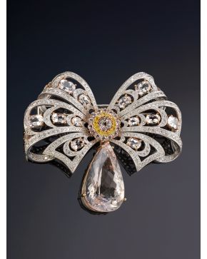 362-BROCHE ESTILO ANTIGUO GRAN LAZADA CUAJADA DE CUARZOS ROSA CON GRAN PERILLA COLGANTE. DECORADO CON LÍNEAS DE BRILLANTES. Montura en oro blanco y rosa de 18k. Firmado Yanes. Peso total aprox. de brillantes: 3ct. 