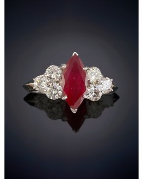 662-ELEGANTE SORTIJA CON UN BELLO RUBÍ CENTRLA, TALLA MARQUISSE DE 2,12CT. APROX. FLANQUEADO POR TRÍOS DE BRILLANTES QUE SUMAN UN TOTAL DE 1,15CT. APROX. Sobre una montura de garras de oro blanco de 18k. 