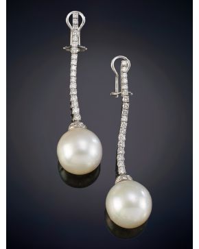 670-ELEGANTES PENDIENTES RIVIERE DE BRILLANTES CON UNA BELLA AUSTRALIANA DE INTENSO ORIENTE, DE 15 MM DE DIÁMETRO. Montura de garras en oro blanco de 18k.Peso total de los brillantes: 1,60ct. aprox. 