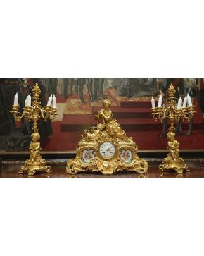 1011-Guarnición compuesta por reloj de sobremesa en bronce dorado y placas de porcelana de Sévres; y candelabros de seis luces a  juego. estilo Luis XV. Fr