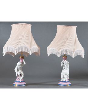 1224-Pareja de lámparas de sobremesa en porcelana y biscuit con fuste en forma de candelero y figuras masculina y femenina en el fuste. Esmaltada en rosa. 