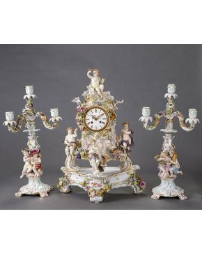 843-Guarnición en porcelana de Meissen formada por: Reloj de sobremesa y pareja de candelabros de cuatro luces convertibles en candelero. Decoración de fl