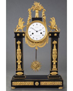 885-Reloj de sobremesa Imperio. c. 1800. En mármol negro de Bruselas y bronce dorado al mercurio. Con decoración de grifos y cariátides en estilo egipcio.