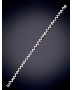 202-ELEGANTE PULSERA CON UN ORIGINAL DISEÑO DE ONDAS DECORADAS CON BRILLANTES sobre una montura de oro blanco de 18K.