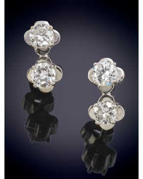 207-BELLOS PENDIENTES CON DOS DIAMANTES CADA UNO, ENMARCADOS EN UNA MONTURA CON DISEÑO DE FLOR en oro blanco de 18K.