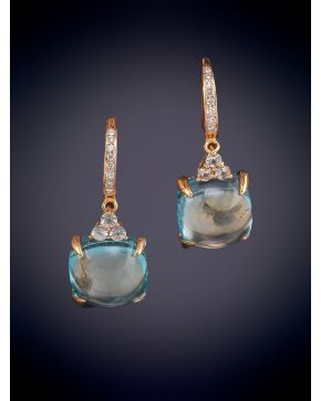 344-BELLOS PENDIENTES CON CABUJONES DE TOPACIO AZUL CORONADO POR TRES BRILLANTES sobre una montura en oro rosa de 18K.