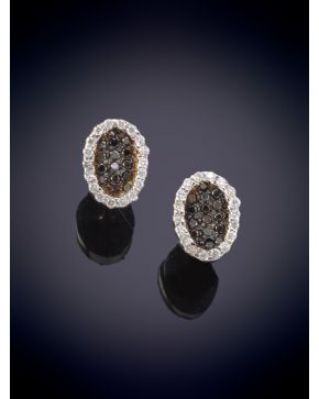 362-ELEGANTES PENDIENTES CON BRILLANTES NEGROS CENTRALES ORLADOS POR UNA LÍNEA DE BRILLANTES BLANCOS sobre una montura en oro blanco de 18K.