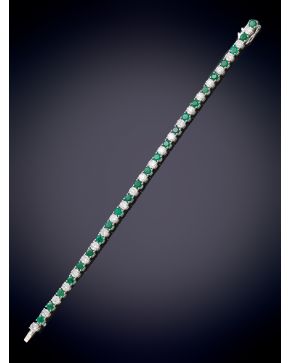 713-ELEGANTE PULSERA RIVIERE DE CON BRILLANTES CON UN PESO DE 5,75CT. APROX. Y ESMERALDAS CON UNH PESO DE 4,60CT. APROX. CALIDAD EXTRA. Clásica montura en garras de oro blanco de 18k.  