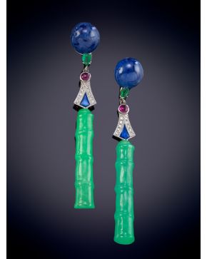 748-ELEGANTES PENDIENTES CON UNA BARRITA DE JADE ONDULADA QUE PENDE DE UNA MONTURA DECORADA POR ZAFIRO, ESMERALDA, RUBÍES Y BRILLANTES en oro blanco de 18K.