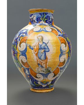 599-Orza en cerámica de Talavera, s. XVII, con representación de Santa Águeda en cartela de cueros retorcidos y motivos vegetales.