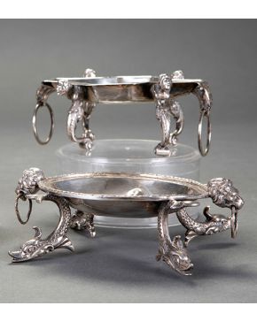 966-Lote de dos piezas en plata antigua, s. XIX. Una con cabezas de león y patas de delfín, la segunda con cabezas de águilas y atlantes. Peso: 620 gr. Medidas: 5,5x9x15 cm.