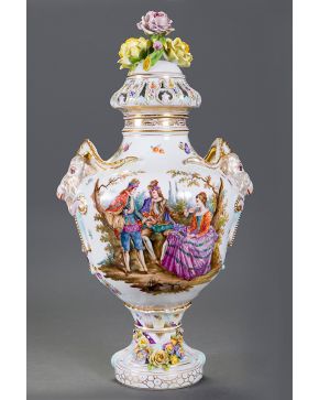 757-Carl Thieme (1816 - 1884). Jarrón con tapa en porcelana de Dresde. Decorado con escenas dieciochescas en el cuerpo y cabezas de carneros en relieve, Tapa con rosas. Con marcas. Restauración antigua en la base.