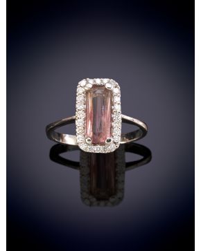 225-ELEGANTE SORTIJA CON UNA TURMALINA ROSA ORLADA POR BRILLANTES sobre una montura en oro blanco de 18K.  