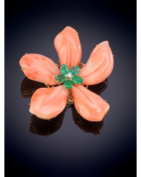 482-ELEGANTE BROCHE EN FORMA DE FLOR CON PÉTALOS EN CORAL PIEL DE ÁNGEL Y CENTRO DE ESMERALDAS TALLA OVAL DE 1,37CT Y UN BRILLANTE CENTRAL sobre una m