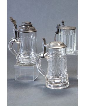 2175-Lote de tres jarras de cerveza o Tankard en cristal centroeuropeo y metal, tapas con inscripciones y dedicatorias. Altura mayor: 20 cm.