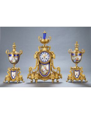 770-Guarnición formada por reloj de sobremesa y dos copas, Francia 2ª mitad del s. XIX. Con monturas en bronce dorado y placas en porcelana de Sévres con decoración de escenas galantes e instrument