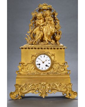 699-Reloj de sobremesa en bronce dorado, Napoleoón III, Francia, s. XIX. Con dorado de gran calidad y remate de escena galante. Esfera con numeración romana. Mecanismo cuerda a llave. Con péndulo y