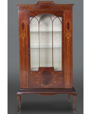 1117-Mueble vitrina, c. 1900. Sobre patas cabriolé, con decoración de marquetería en el frente en maderas frutales y teñidas y tres arcos apuntados en la puerta. Frente y laterales en cristal. Bald