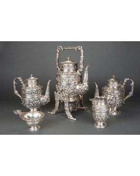 613-Juego de café y té en plata española punzonada compuesto por: samovar, cafetera, tetera, colador y jarrita. Profusa decoración cincelada e historiada con motivos figurativos, a candelieri y mascar