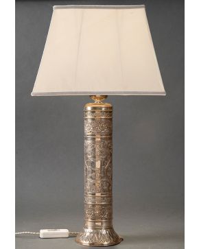 480-Lámpara de sobremesa con fuste en plata española punzonada, ley 925. Decoración relevada de motivos vegetales y palmetas. Altura: 55 cm.