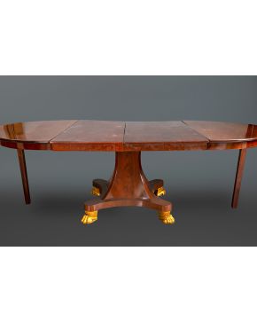 806-Elegante mesa de comedor Regencia, Inglaterra, S. XIX. En madera de caoba tallada  con patas de garra en bronce dorado. Con 2 extensiones Medidas: 75,5 x 126 cm. 