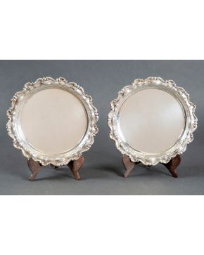 657-Elegante pareja de platos en plata española punzonada de Matilde Espuñes con alero decorado con tornapuntas relevadas y trabajo martelé.  Peso: 865 gr Diámetro mayor: 30 cm 