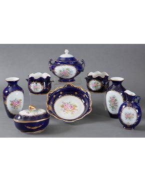 2182-LIMOGES Conjunto en porcelana azul cobalto con decoración central de flores y filos dorados. Formado por dos floreros, terrina, pequeña sopera, fuente redonda honda, jarro y dos recipientes co