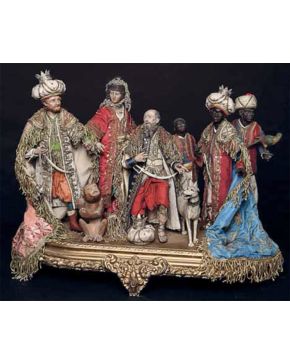 1063-ESCUELA NAPOLITANA  Escena oriental  Conjunto formado por tres reyes magos vestidas con teles antiguas de San Leucio, Georgiana con espada, Moretto pequeño, Moro con loro, galgo en madera c