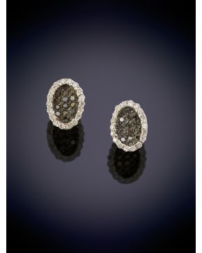 229-BELLOS PENDIENTES CON CENTRO DE BRILLANTES NEGROS Y UNA ORLA DE BRILLANTES BLANCOS sobre una montura en oro blanco de 18K.