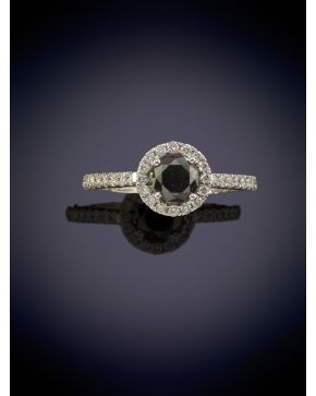 487-ELEGANTE SORTIJA CON UN DIAMANTE CENTRAL NEGRO DE 0,50CT Y UNA ORLA DE DIAMANTES BLANCOS DE 0,35CT sobre una montura en oro blanco de 18