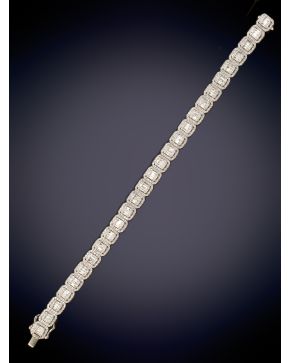 686-ELEGANTE BRAZALETE COMPUESTO POR MÓDULOS DE DIAMANTES BAGUETTE CENTRALES ORLADOS POR BRILLANTES sobre una montura en oro blanco de 18K.