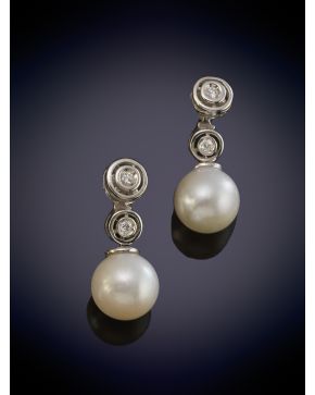 89-ELEGANTES PENDIENTES DE PERLAS CULTIVADAS QUE PENDEN DE DOS CHATONES DE BRILLANTES sobre una montura en oro blanco de 18K.