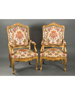 2165-Pareja de sillones estilo Luis XV en madera tallada y dorada con decoración de rocallas y tapicería estampada. Altura: 115 cm.