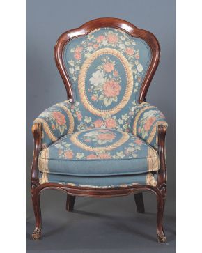 2177-Sillón siglo XX en madera con respaldo curvo y tapizado en tela azul con flores de tonos rosas y verdes.. Altura: 105cm