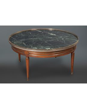 2182-Mesa baja de centro circular estilo Luis XVI.  En madera con tapa en mármol verde y galería en bronce calada. Con patas acanaladas y contarios de