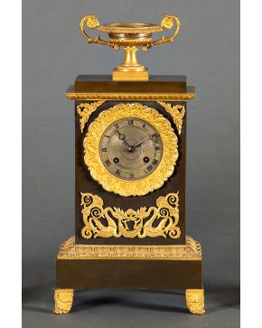 865-Reloj de sobremesa estilo Imperio en bronce pavonado y dorado con remate de copa clásica.  Medidas: 36 cm.