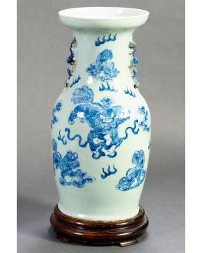 465-Jarrón chino en porcelana esmaltada blanca con decoración vegetal y quimera en azul, ca. 1900. Sobre peana en madera tallada. Altura: 42 cm.