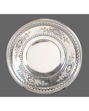 1107-Elegante plato en plata sterling con alero calado y cincelado con decoración de hojas y flores.  Peso: 380 gr. Diámetro: 27 cm.