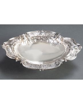 1072-Pieza ovalada para frutas sobre cuatro pies en plata sterling con perímetro ondulado elegantemente cincelado con motivos de flores y tornapuntas 