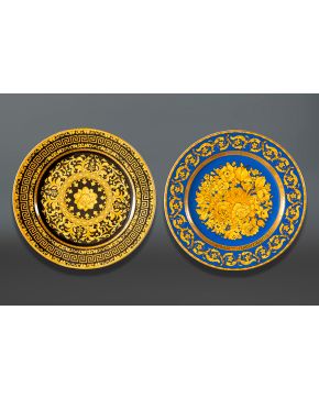 1333-VERSACE Lote de dos platos en pocelana con detalles en amarillo, negro y azul decorado con flores y formas onduladas.  Diámetro, 31 cm 