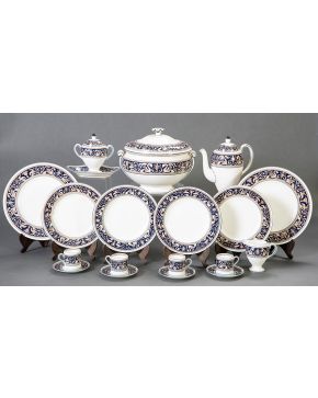 650-Elegante vajilla Wedgwood, con marcas, en porcelana blanca con cenefa azul en el filo con motivos de Candelieri. Se compone por 24 platos llanos, 