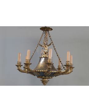 2202-Lámpara de techo de ocho luces estilo imperio en bronce dorado con remate de niño sosteniendo cadenas. Altura: 60 cm aprox.