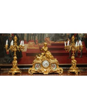 881-Guarnición compuesta por reloj de sobremesa en bronce dorado y placas de porcelana de Sévres, y candelabros de seis luces a  juego, esti