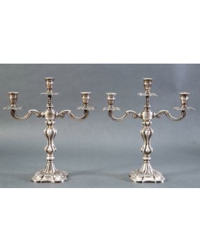 1041-Pareja de candelabros de tres luces estilo Luis XV en plata española punzonada con marcas de Montejo. Base cuadrangular con filo de dec