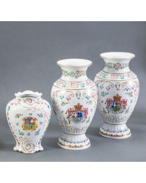 738-Conjunto de tres jarrones en porcelana blanca esmaltada con decoración de roleos y escudos heráldicos. Siguiendo modelos de Compañía de 