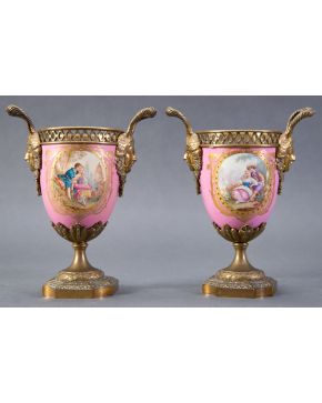 880-Pareja de vasos a modo de jarrones en porcelana rosa con escena de fête galante estilo Sévres, s. XIX. Pie y asas con mascarores en bron