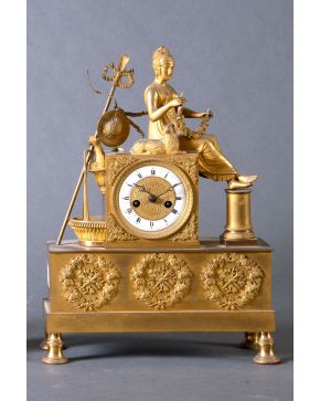 988-Reloj de sobremesa estilo Imperio, Francia, s. XIX. Realizado en bronce dorado, esfera con guilloché y numeració romana e importante rem