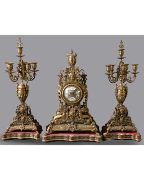 1133-Reloj de sobremesa con guarnición de candelabros de cinco luces, España s. XIX, estilo Luis XV. Realizado bronce dorado con profusa dec