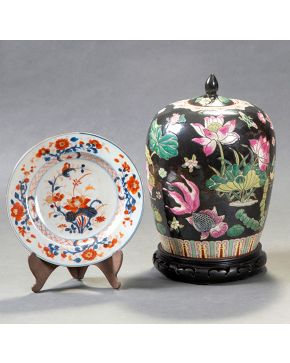 2177-Lote oriental compuesto por un tibor en porcelana de fondo negro y decoración de flores blancas sobre peana de made